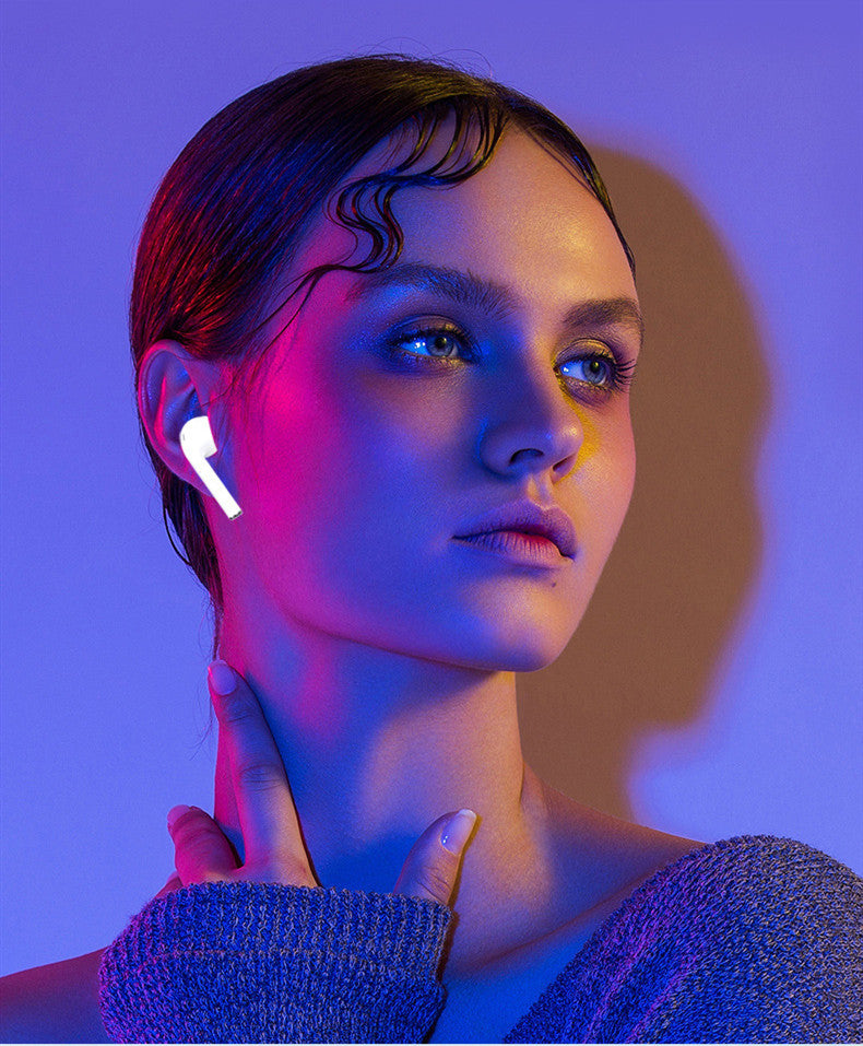 Person wearing a futuristic earbud with a blue and purple color scheme