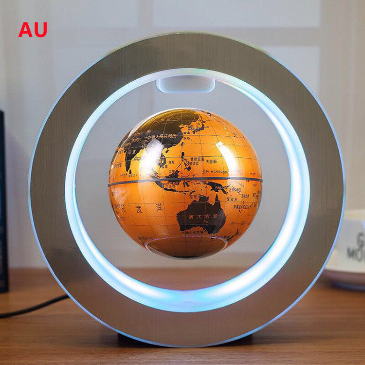 Levitating orange globe with a circular light base on a wooden surface.