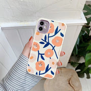 Phone case with floral design held by a person against a white background