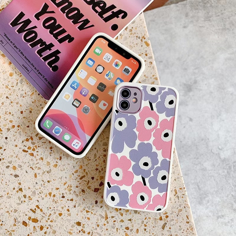 Two phone cases on a textured surface with a book in the background.