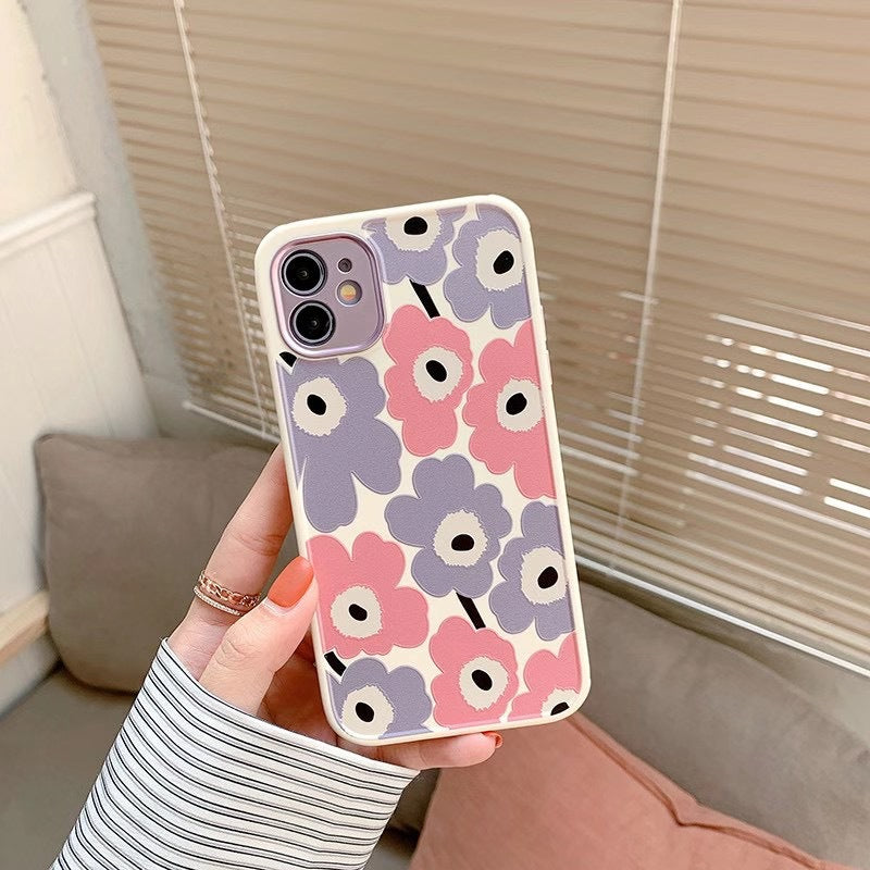 Phone case with floral pattern held by a person indoors