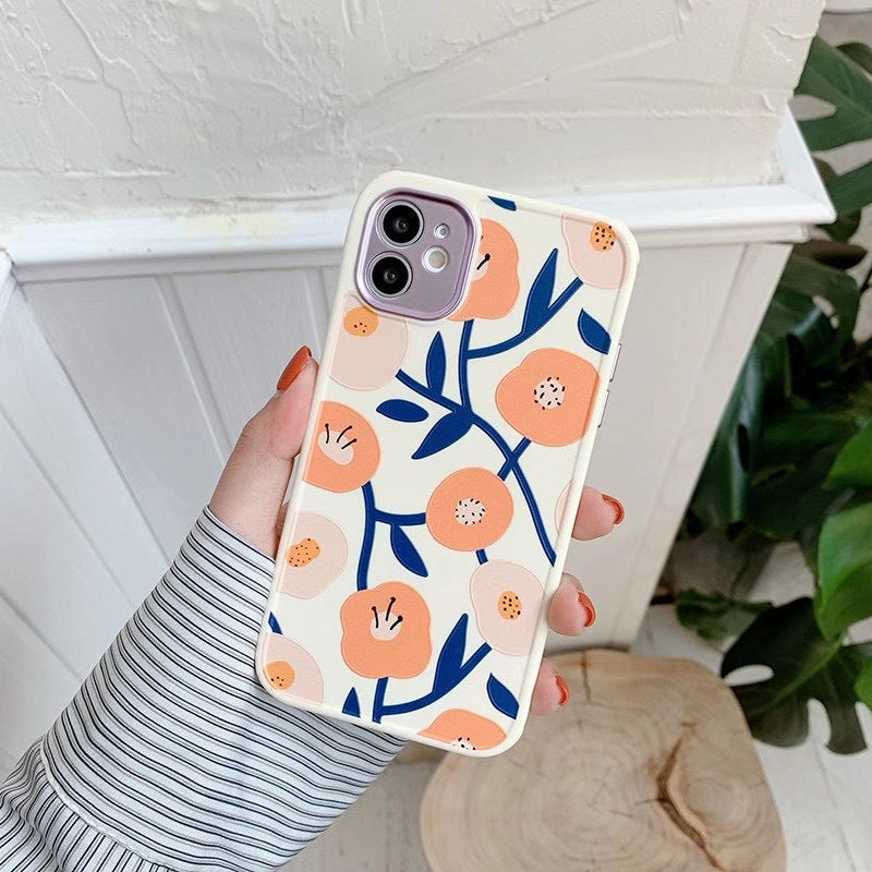 Phone case with floral design held by a person against a white background
