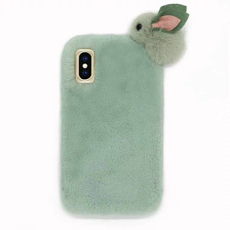 Green fluffy phone case with a small plush toy on a white background