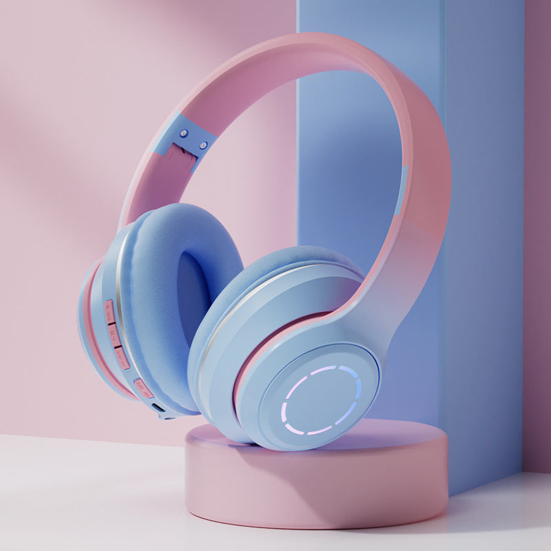 Pastel blue and pink headphones on a pink platform with a soft pastel background