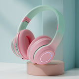 Pink and green headphones on a stand with a light blue background