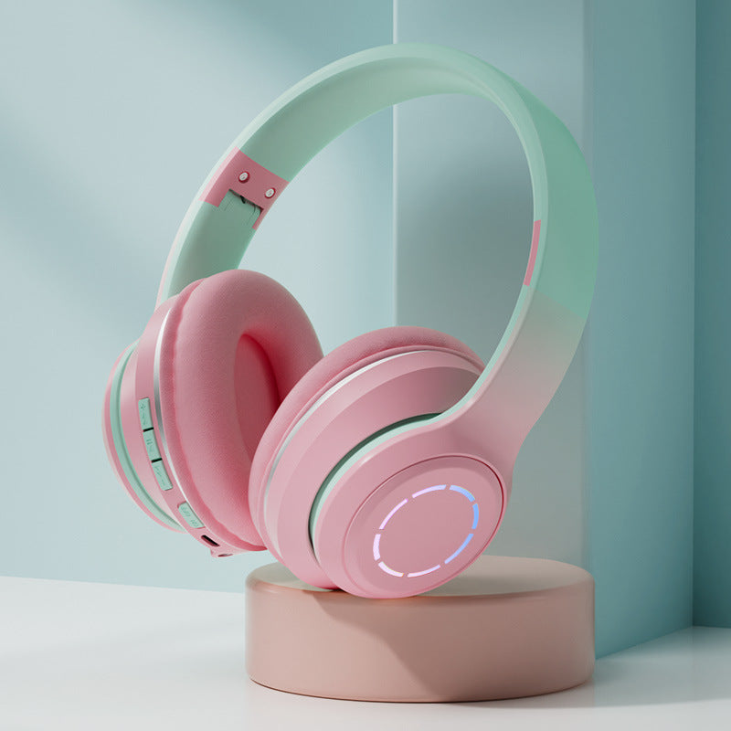 Pink and green headphones on a stand with a light blue background