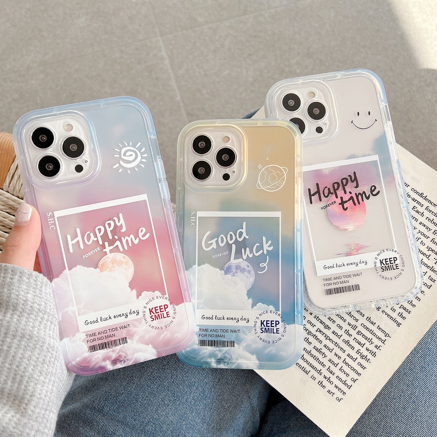 Three phone cases with motivational phrases held by a person on a textured surface.