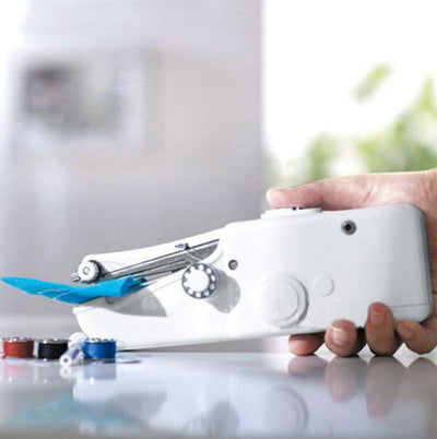 Hand holding a white sewing machine with blue accents on a reflective surface.