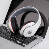 White headphones with red accents on a laptop keyboard