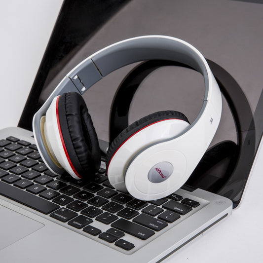 White headphones with red accents on a laptop keyboard