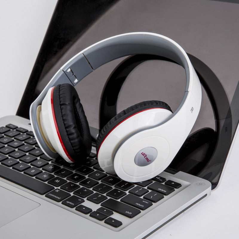 White headphones with red accents on a laptop keyboard