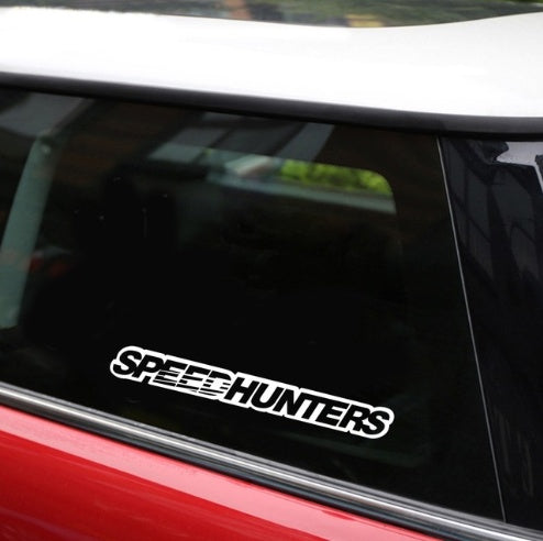 Car window with 'Speedhunters' decal on a reflective surface