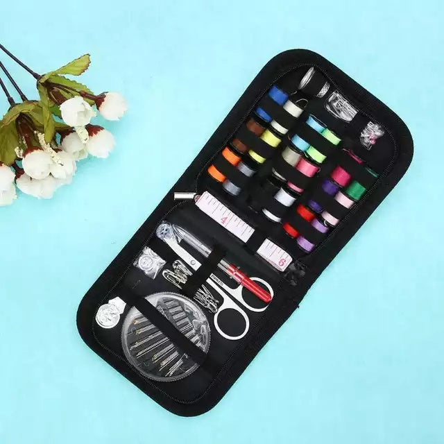 Sewing kit with various tools in a black case on a light blue background