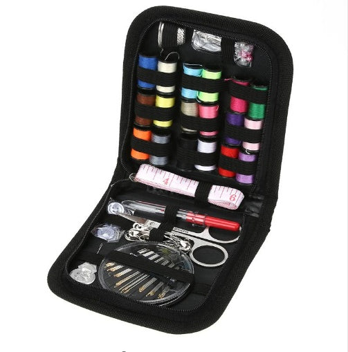 Sewing kit with colorful thread spools, scissors, and other tools in a black case on a white background.