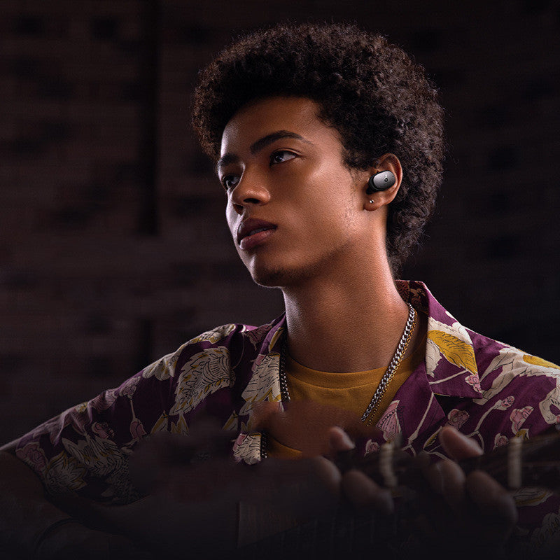 Person wearing wireless earbuds with a dark background