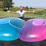Person on a trampoline with large blue and pink bubbles in front