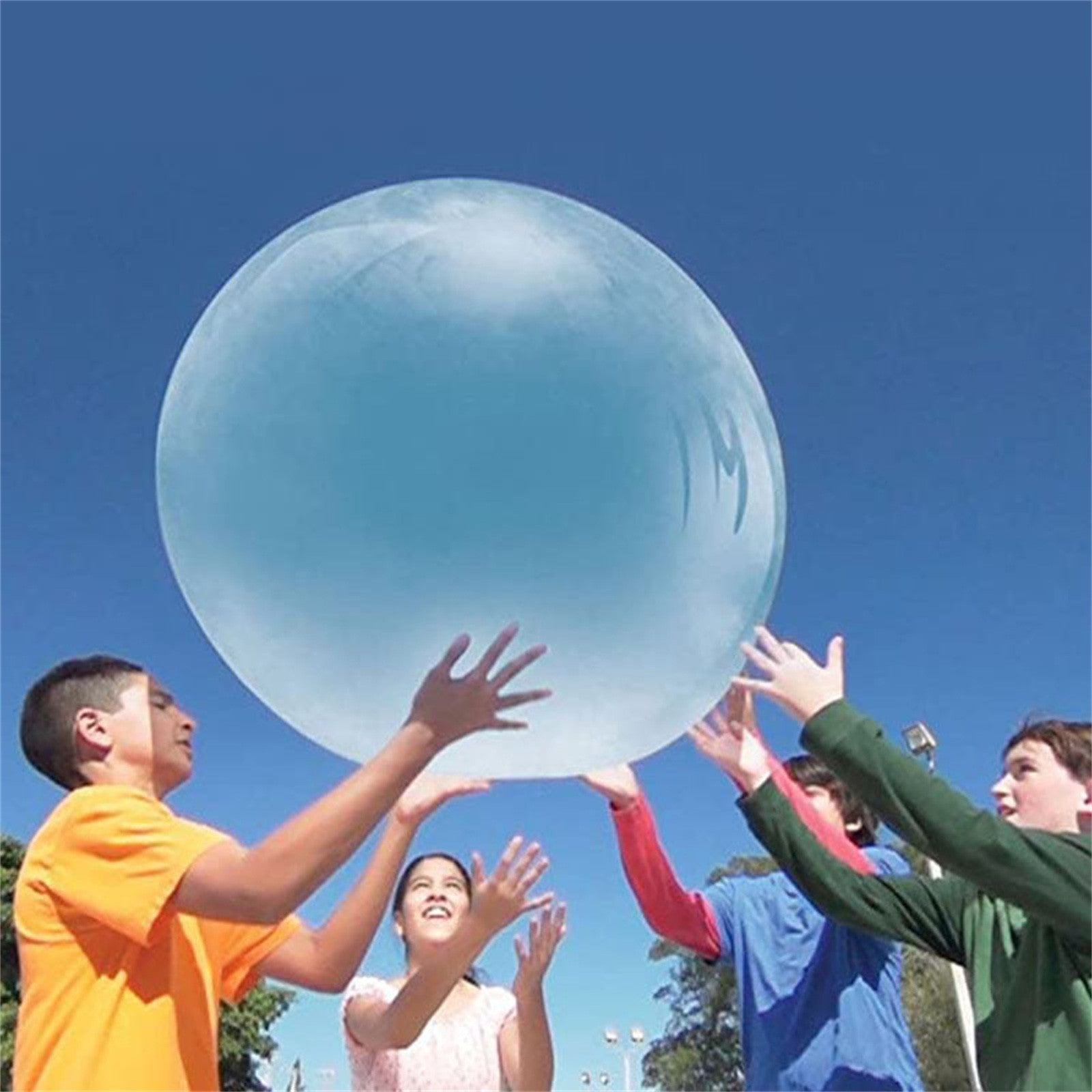 Children playing with a large blue bubble under a clear blue sky
