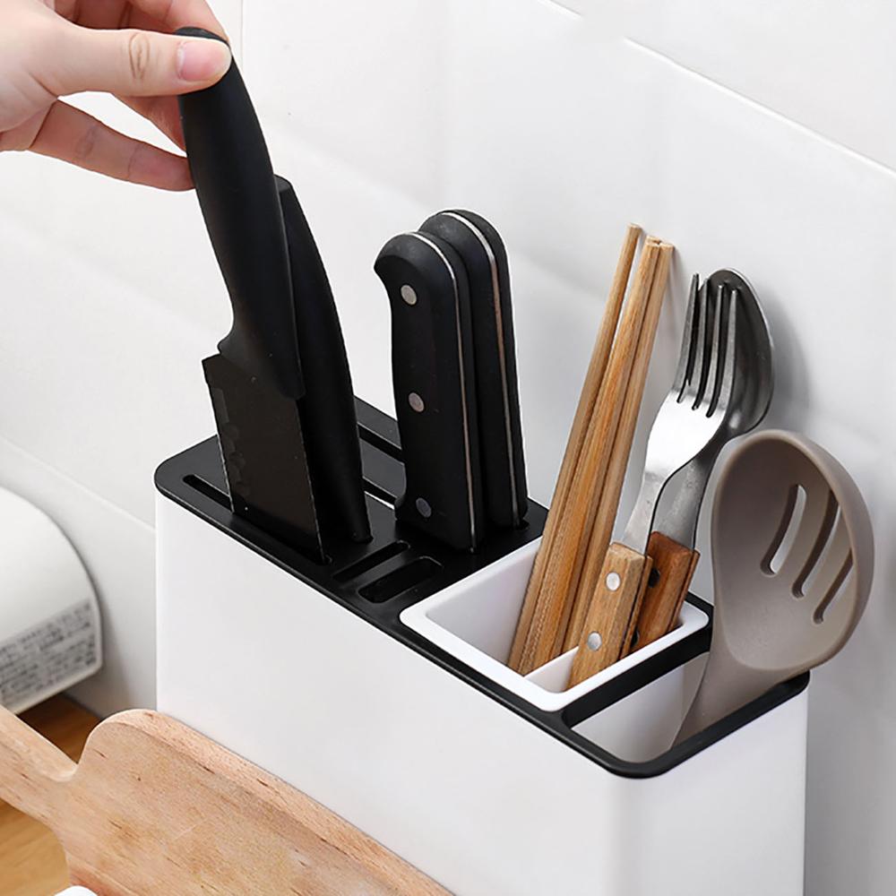 Kitchen utensil holder with knives, chopsticks, and a spatula on a white background