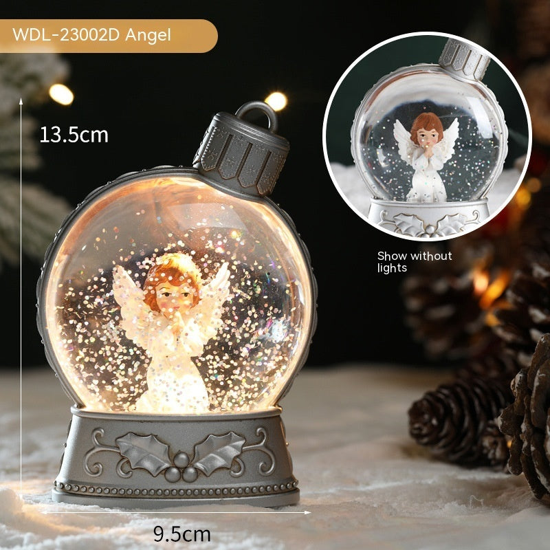Decorative angel snow globe with lights and measurements, surrounded by pine cones.