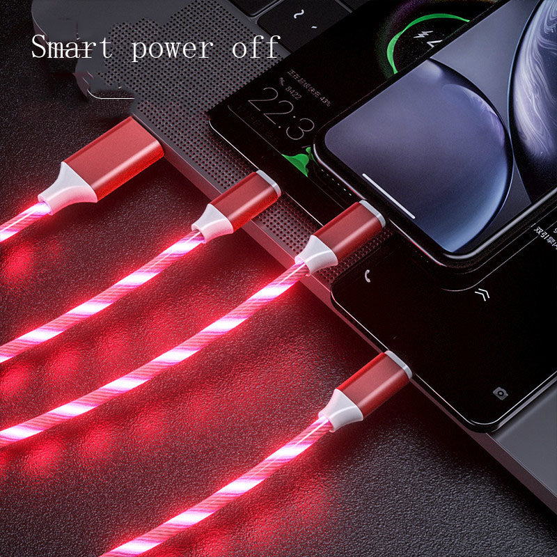 Red LED cable connected to a smartphone and laptop on a dark surface