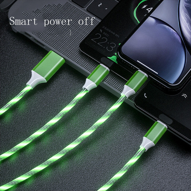 Green LED cable charging multiple devices on a dark surface