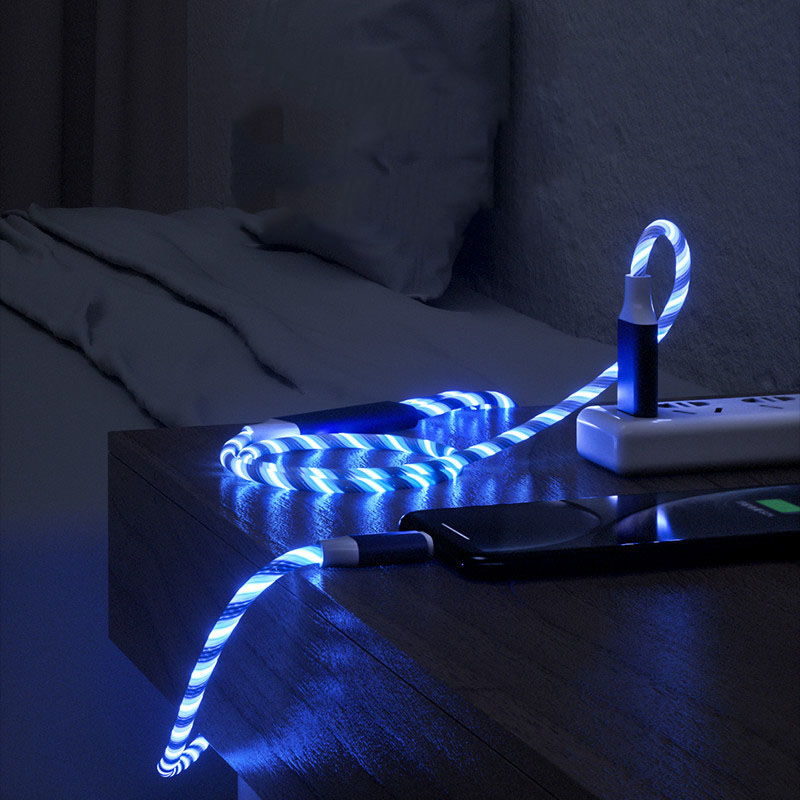 Blue LED strip light on a nightstand with smartphone and remote control.