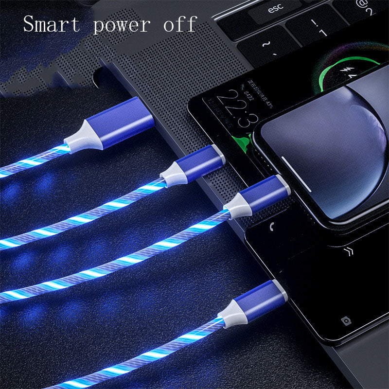 Blue LED cable connected to a laptop and phone on a dark surface