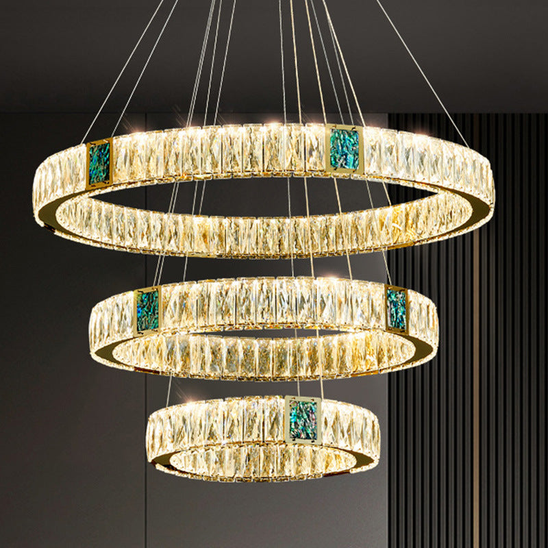 Three-tiered chandelier with crystal accents on a dark background