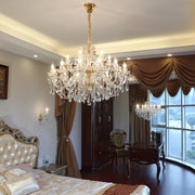Luxurious bedroom with crystal chandelier, large window, and elegant furniture.