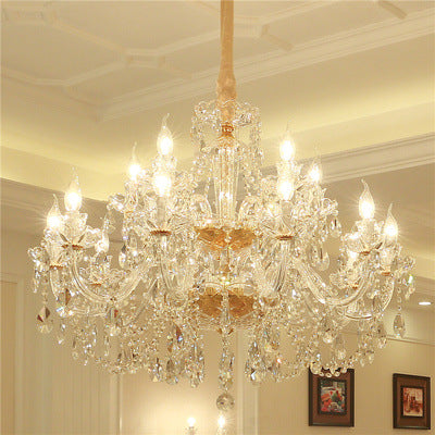 Crystal chandelier hanging in a room with framed pictures on the wall.
