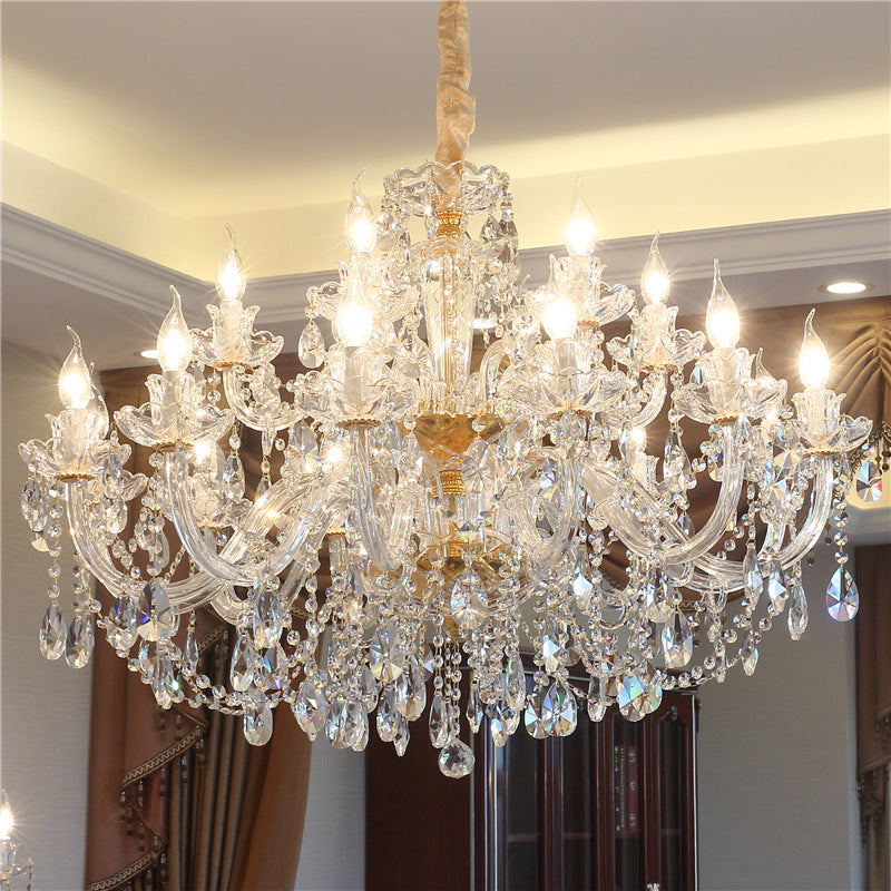 Crystal chandelier hanging in a room with neutral walls and a door.