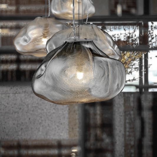 Close-up of a modern pendant light with textured glass shade in an indoor setting.