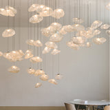 Modern chandelier with glass shades hanging in a room with a dining table.
