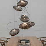 Modern pendant lights hanging above a dining table with a neutral background