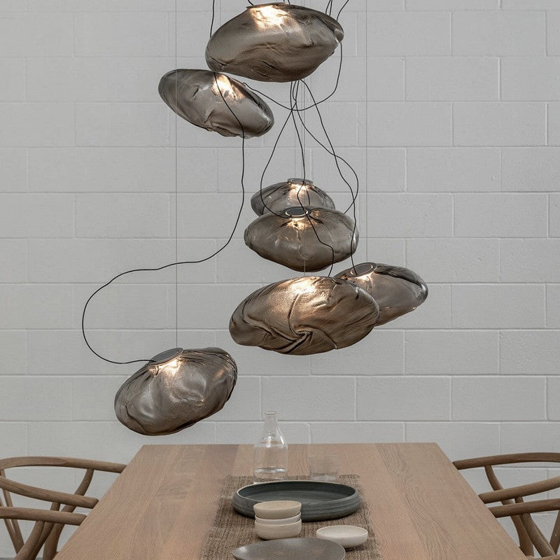Modern pendant lights hanging above a dining table with a neutral background
