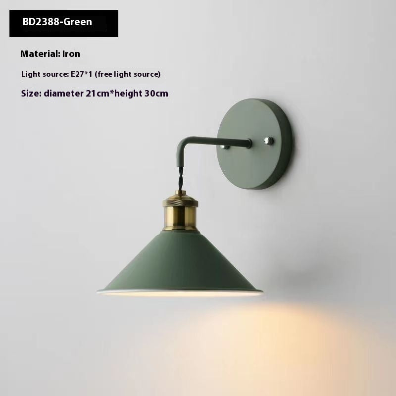 Green wall lamp with brass accents on a white background