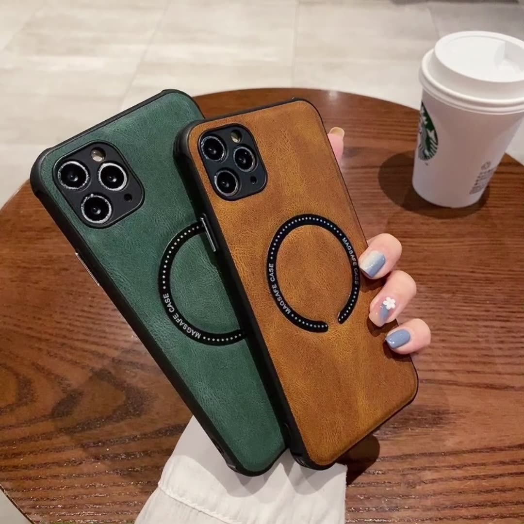 Two phone cases, one green and one brown, held by a hand on a wooden surface with a Starbucks cup in the background.