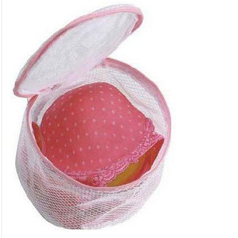 Pink bra in a mesh laundry bag on a white background