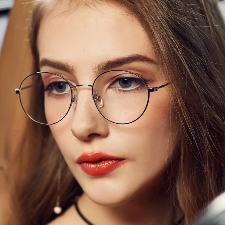 Close-up of a person wearing round glasses with a blurred background