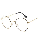 Round eyeglasses with gold frame and black arms on a white background