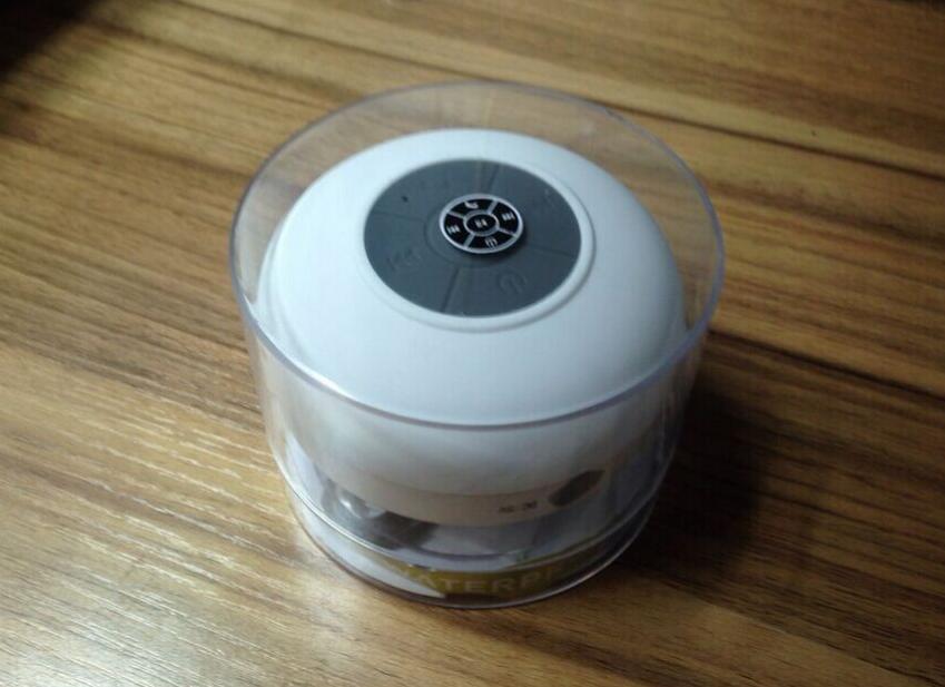 White electronic device with a black circular component on a wooden surface