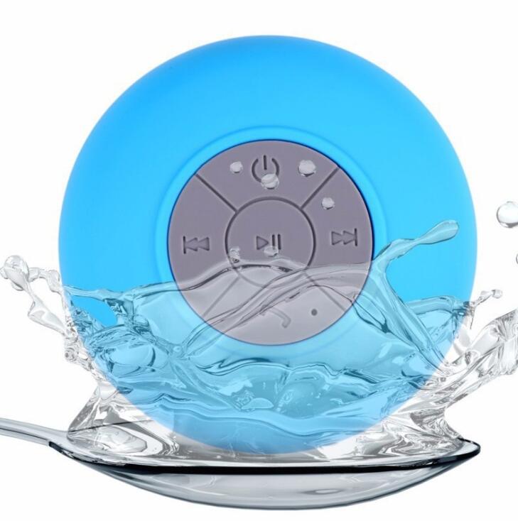 Blue waterproof Bluetooth speaker with water splashes on a white background