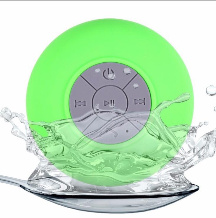 Green Bluetooth speaker with water splashes on a white background