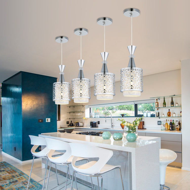 Modern kitchen with pendant lights and white bar stools.