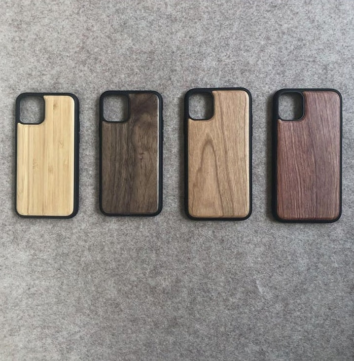 Four wooden phone cases on a gray surface