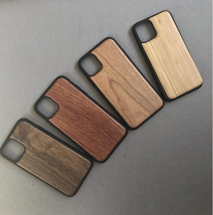Four wooden phone cases on a gray surface