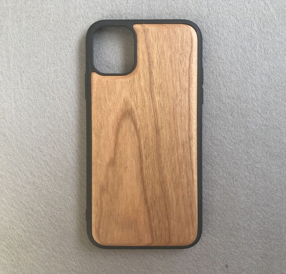 Wooden phone case with black border on a gray background