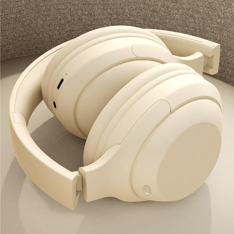 Beige headphones on a light gray surface with a neutral background