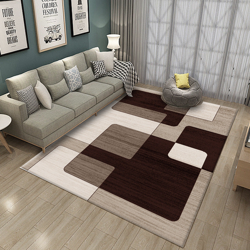Living room with a checkered brown and beige rug, gray sofa, and decorative pillows.