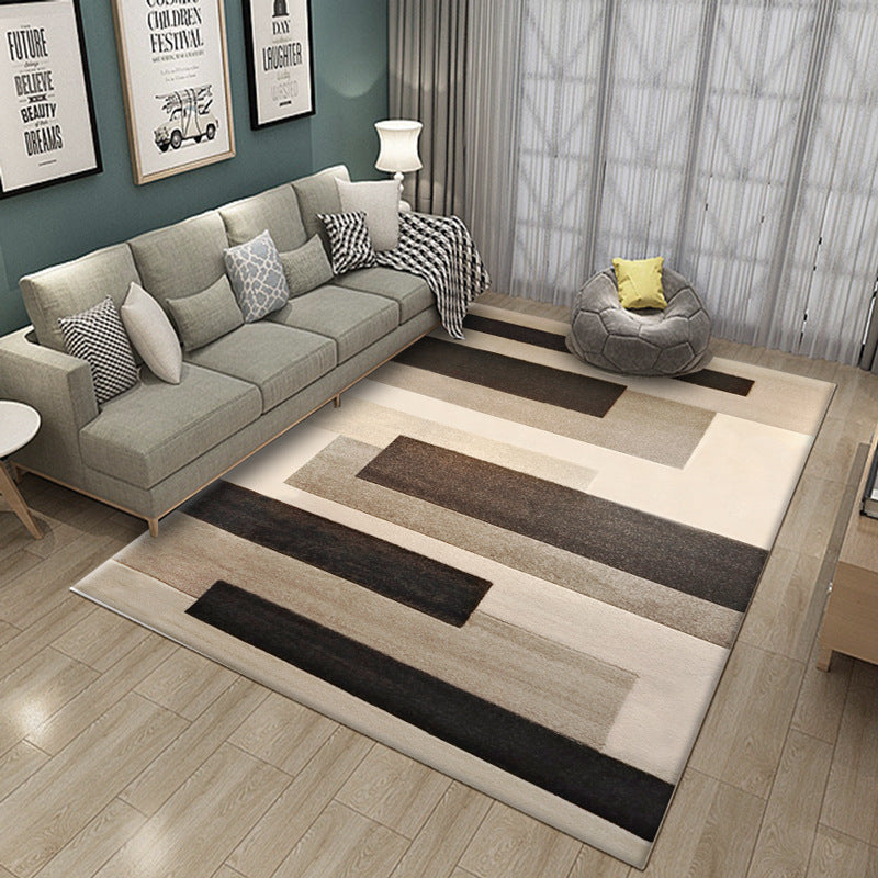 Living room with a patterned rug, gray sofa, and decorative pillows.